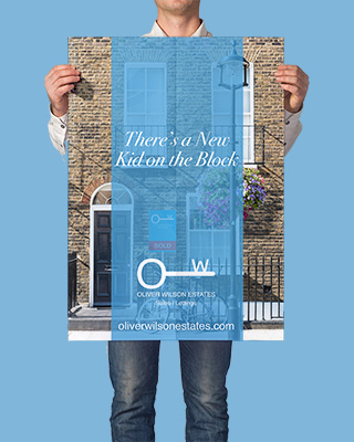 An image of a person holding up a poster featuring artwork designed by Seaweed & Spruce.