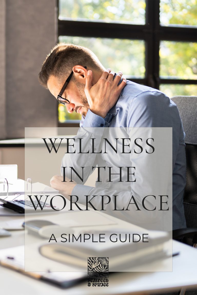 An image of a man sitting at his desk with one hand cradling his neck as though he is experiencing some discomfort. Office Wellness.